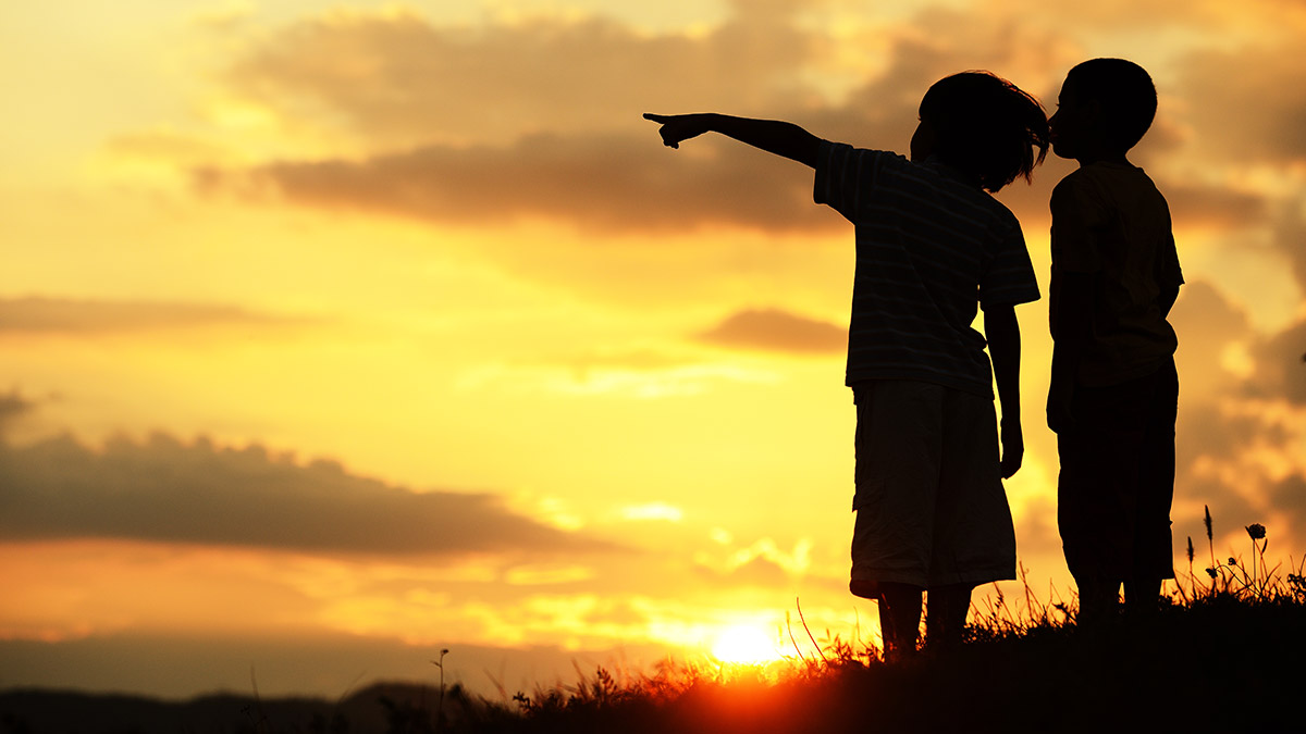 Pointing to the horizon at sunset